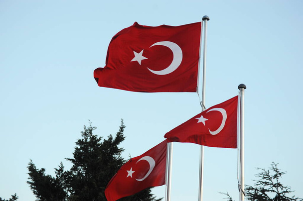 Κωνσταντινούπολη / Τουρκία - 02.24.2017: Η εθνική σημαία της Τουρκίας σε τρεις στύλους σημαίας στο δρόμο. - Φωτογραφία, εικόνα