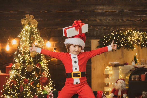 Hauska pieni poika lapsi läsnä tai lahjapakkauksessa sisätiloissa. Uusi vuosi joulun konsepti. Talvi joulun tunteet
. - Valokuva, kuva