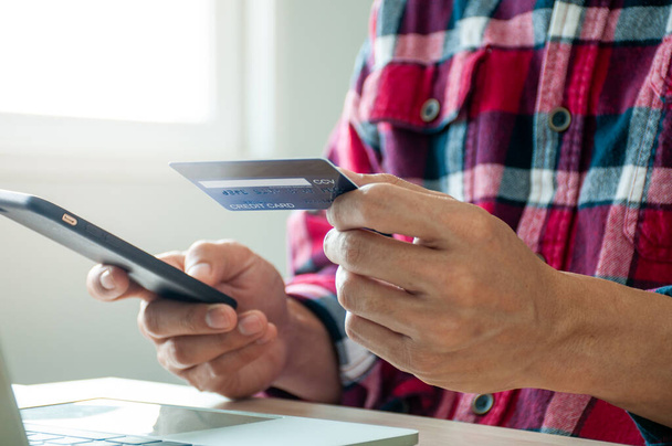 Мужские руки используют кредитные карты для онлайн-покупок через смартфоны. Оплата продуктов онлайн
 - Фото, изображение
