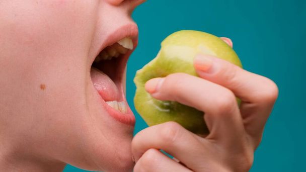 Egészséges táplálkozás és egészséges fogak vagy étrend, fiatal nő harap egy friss alma közelkép. - Fotó, kép