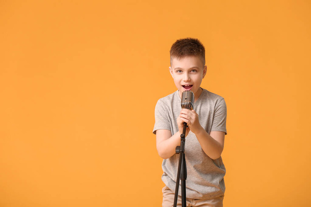 Милый мальчик поет на цветном фоне - Фото, изображение