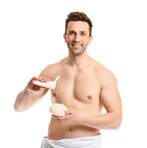 Handsome man with shower gel and loofah on white background - Fotó, kép