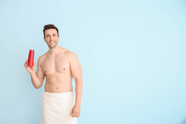 Handsome man with shower gel on color background - Foto, afbeelding