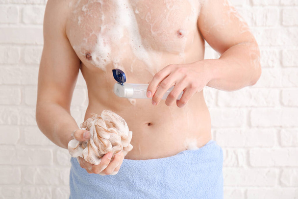 Hezký muž se sprchuje na bílém pozadí - Fotografie, Obrázek