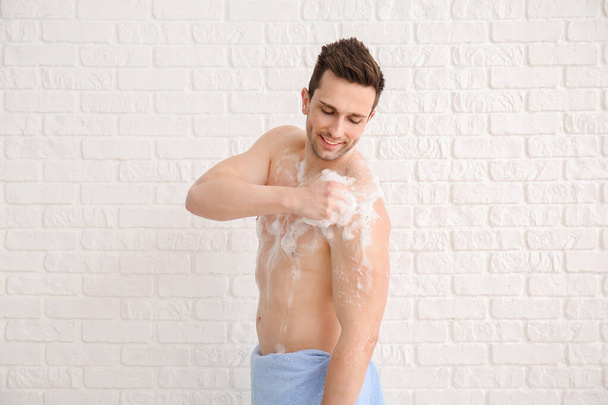 Красивий чоловік приймає душ на білому тлі
 - Фото, зображення