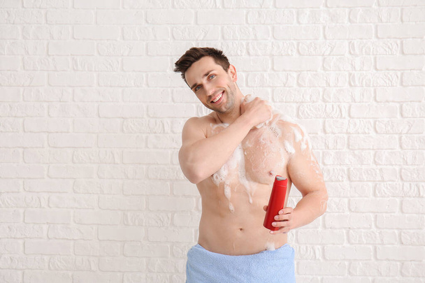 Hombre guapo tomando ducha sobre fondo blanco
 - Foto, imagen