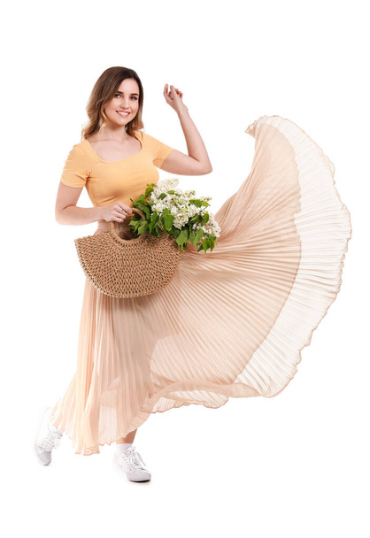 Kaunis nuori nainen kukkakimppu lila kukkia valkoisella taustalla
 - Valokuva, kuva