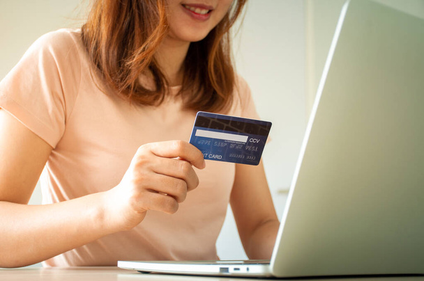 Women's hands are using computers and credit cards to order products online. - Photo, Image