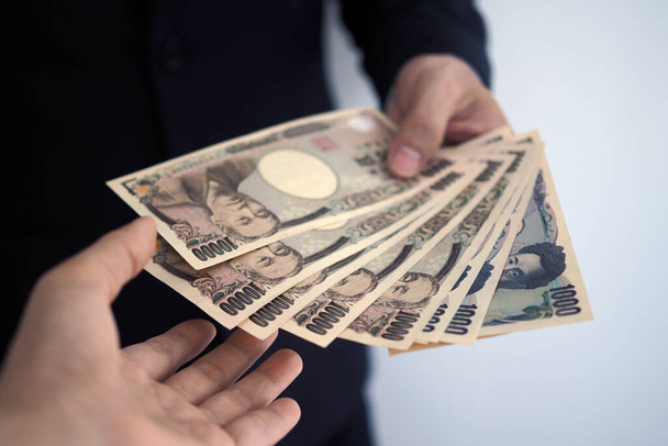 Businessmen send Japanese banknotes to employees. - Photo, Image