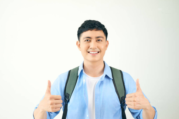 Νεαρός άνδρας δίνει δύο αντίχειρες επάνω απομονωμένος σε λευκό φόντο - Φωτογραφία, εικόνα