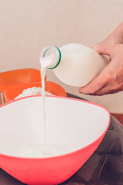 Mixing batter for pancakes - vertical frame - adding milk, eggs, flour, sugar - Фото, изображение