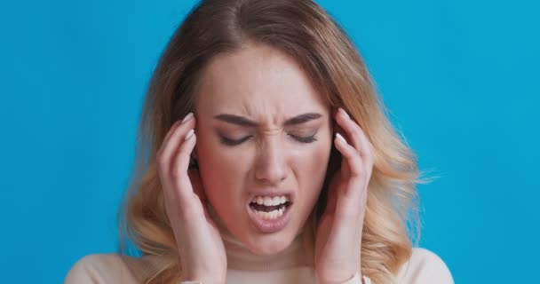 Trpící žena s bolestí hlavy dotýkající se spánků - Záběry, video