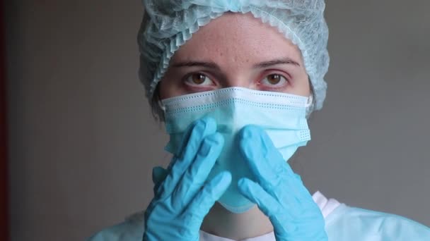 doctor in medical rubber gloves corrects a medical mask on his face - Video, Çekim