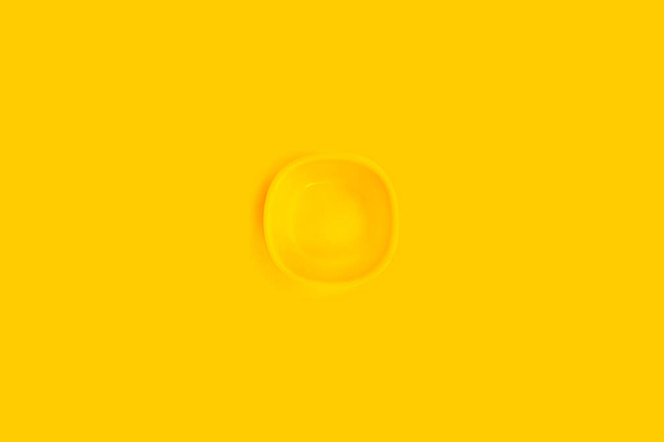 Yellow plate on a yellow background. - Photo, Image
