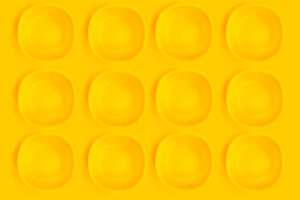 Yellow plates on a yellow background. - Photo, Image