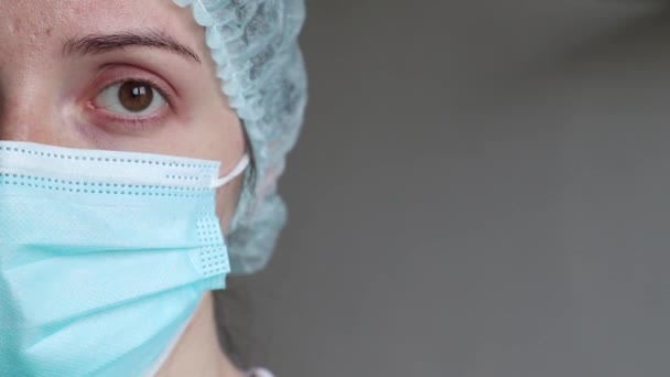 portrait of a doctor in a medical mask, left side of the face - Filmati, video