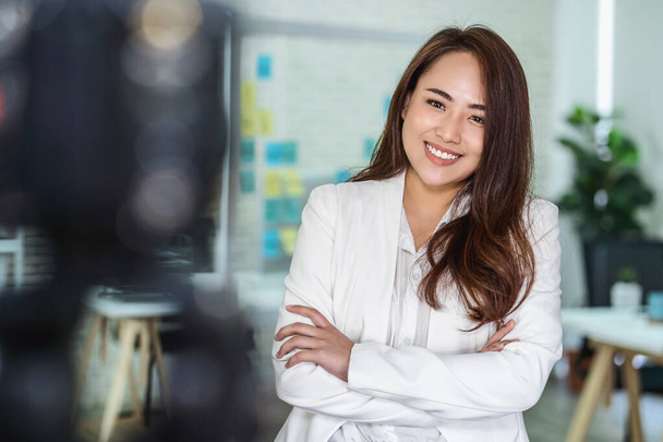 Ritratto di donna d'affari asiatica con i pollici in su come quando registra il video per influenza sociale sul posto di lavoro moderno
 - Foto, immagini
