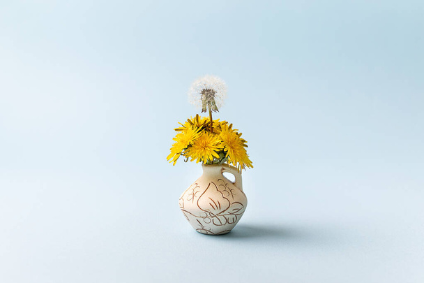 Diversity identity, community, unity, togetherness support concept. Yellow dandelion flowers and one flower with seeds on a blue background. - Photo, Image