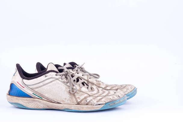 Oude vintage beschadigde futsal sportschoenen op witte achtergrond geïsoleerd  - Foto, afbeelding