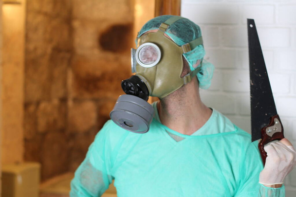 close-up retrato de maníaco médico em máscara de gás e serra
 - Foto, Imagem