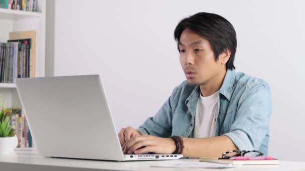 Asiatische Gelegenheitsunternehmer oder Freiberufler arbeiten von zu Hause aus mit Videokonferenz-Laptop. Gelegenheitsunternehmer oder Freiberufler in ernsthafter Emotion im Geschäftskonzept - Filmmaterial, Video