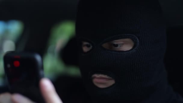 Der Terrorist verhandelt auf einem Smartphone und schüchtert die Menschen ein - Filmmaterial, Video