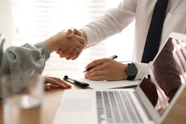 Empresários apertando as mãos no escritório, close-up
 - Foto, Imagem