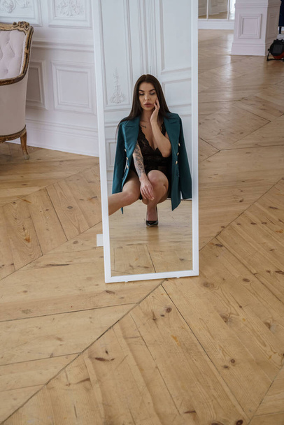Beautiful brunette model wearing black lingerie, high heels and casual jacket posing at luxury apartments interior  - Φωτογραφία, εικόνα