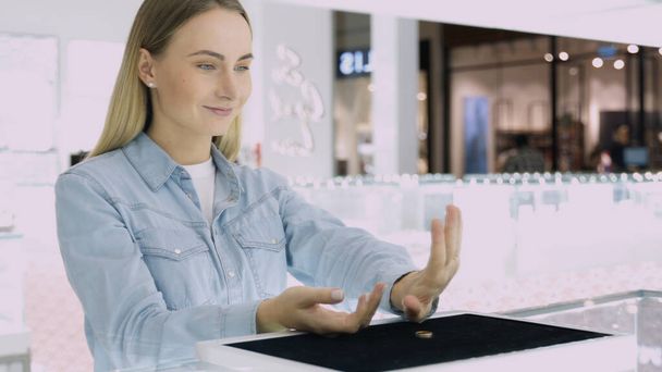 Shot of attractive young woman out shopping for jewelry. Girl lookin at he hand trying to choose rings. - Fotoğraf, Görsel