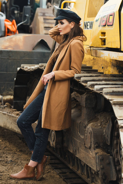 young woman posing near excavator - 写真・画像