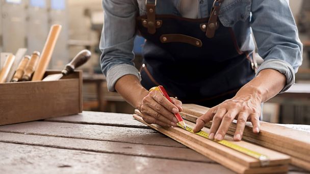 Tesař pracuje s vybavením na dřevěném stole v truhlárně. žena pracuje v truhlářství shop. - Fotografie, Obrázek