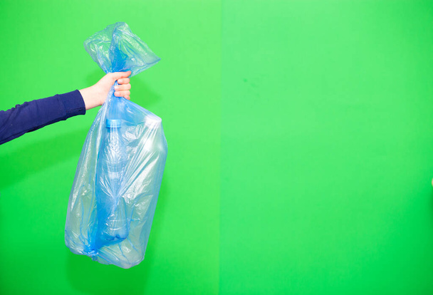 plastový sáček v dětském držení ruky, ruka nese plastové sáčky na odpadky izolované na zelené obrazovce - Fotografie, Obrázek