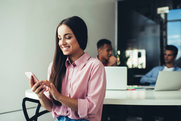 Happy Caucasian woman connecting to 4g in office for surfing social networks during work break, cheerful female employer checking received email and smiling indoors enjoying mobile communication - Foto, Bild