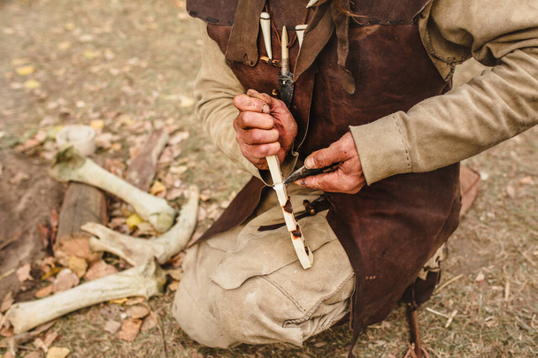 Demonstration of life and lifestyle in the Stone Age - a man makes fire - Photo, image
