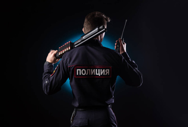 Um tipo bonito de uniforme de polícia com uma arma. tradução para inglês "Police
" - Foto, Imagem