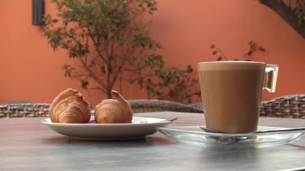 Coffee and croissant on the bar terrace with warm tones in summer. - Footage, Video