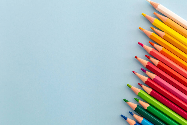une sélection de crayons de couleur arc-en-ciel placés dans une ligne allant de foncé à clair - Photo, image