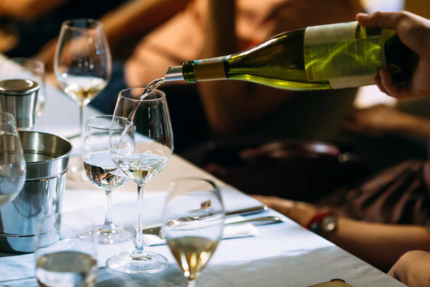 Kellner gießt Wein in ein Glas servierten Tisch - Foto, Bild