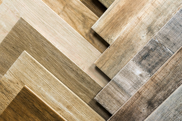Різноманітність дерев'яної плитки. Зразки підробленої дерев'яної плитки для підлоги. Асортимент підлогового ламінату / плитки в інтер'єрі магазину
. - Фото, зображення
