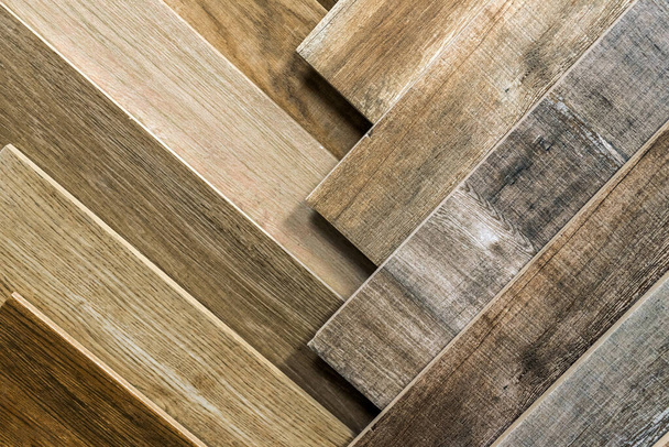 Variedad de madera como azulejos. Muestras de baldosas de madera falsa para suelos. Surtido de suelo laminado / azulejos en una tienda interior. - Foto, imagen