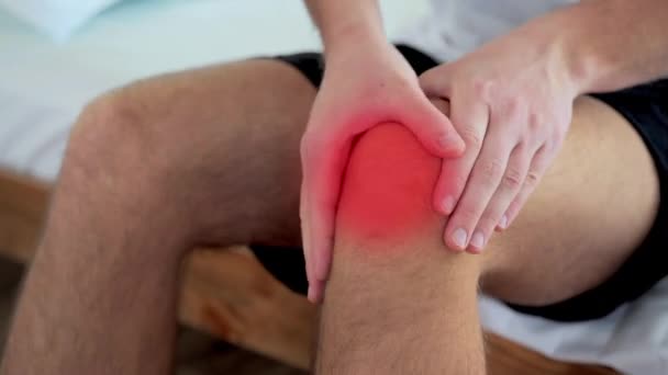 膝を痛めてる患者だ。膝の痛みを持つ男。慢性膝の問題と痛みを持つ男痛みを伴う足の上に手で男 - 映像、動画