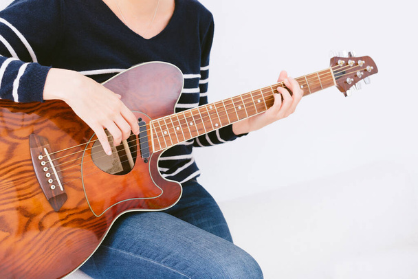 Kobieta grająca na gitarze w relaksujący sposób. ukierunkowanie selektywne - Zdjęcie, obraz