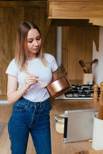 Portret blondynki używającej tabletu do gotowania w kuchni - Zdjęcie, obraz