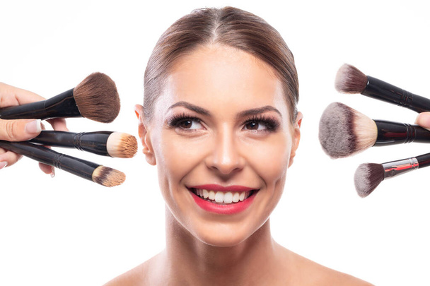 Pretty woman and a bunch of makeup brushes, beauty concept - Foto, Bild