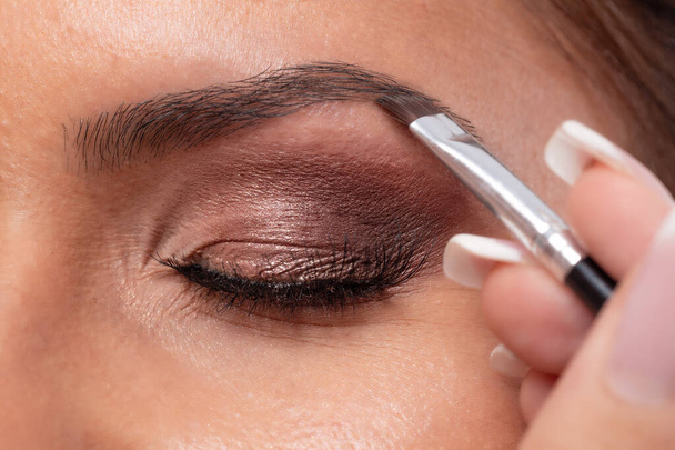 Füllen der Augenbraue mit natürlichem farblich passendem Make-up, wodurch ein hübsches Aussehen entsteht  - Foto, Bild
