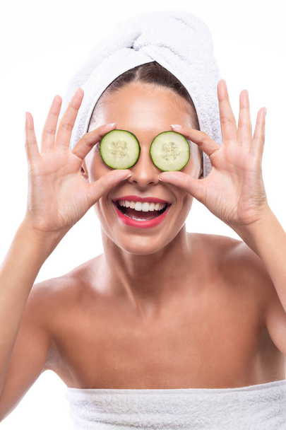 Lovely brunette using cucumber as a natural skin remedy stimulating antioxidant activities - Photo, image