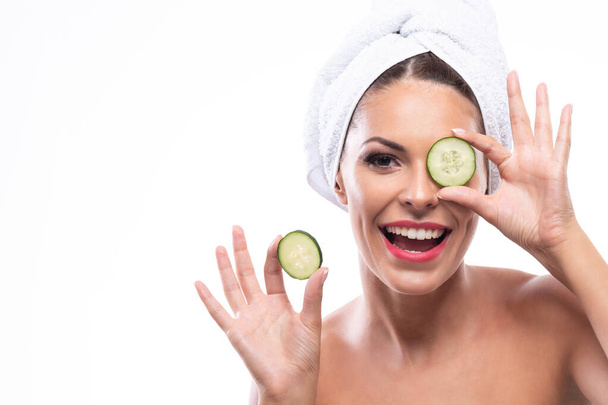 Attractive woman using cucumbers as a beauty remedy, natural skin rejuvenation  - Φωτογραφία, εικόνα
