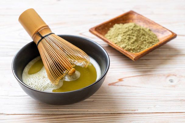 hot matcha green tea cup with green tea powder and bamboo whisk - Foto, imagen