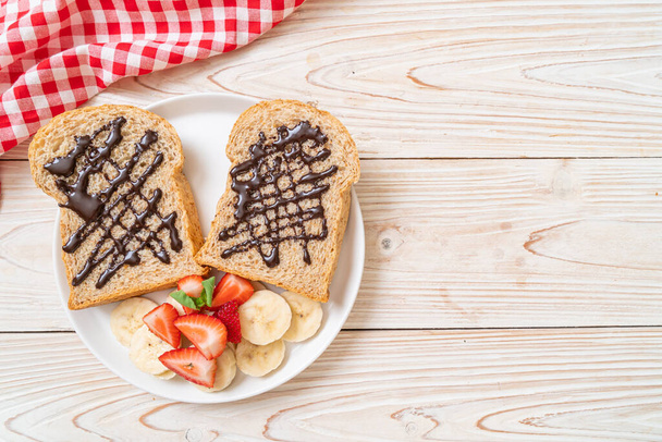 whole wheat bread toasted with fresh banana, strawberry and chocolate for breakfast - Foto, Imagem