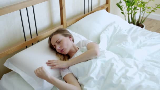Woman with insomnia cant sleep at night. She tosses and turns in bed - Záběry, video